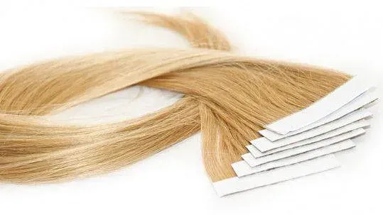 Un primer plano de un montón de extensiones de cabello sobre una superficie blanca.