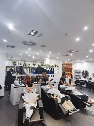 Un grupo de personas se están lavando el cabello en un salón.