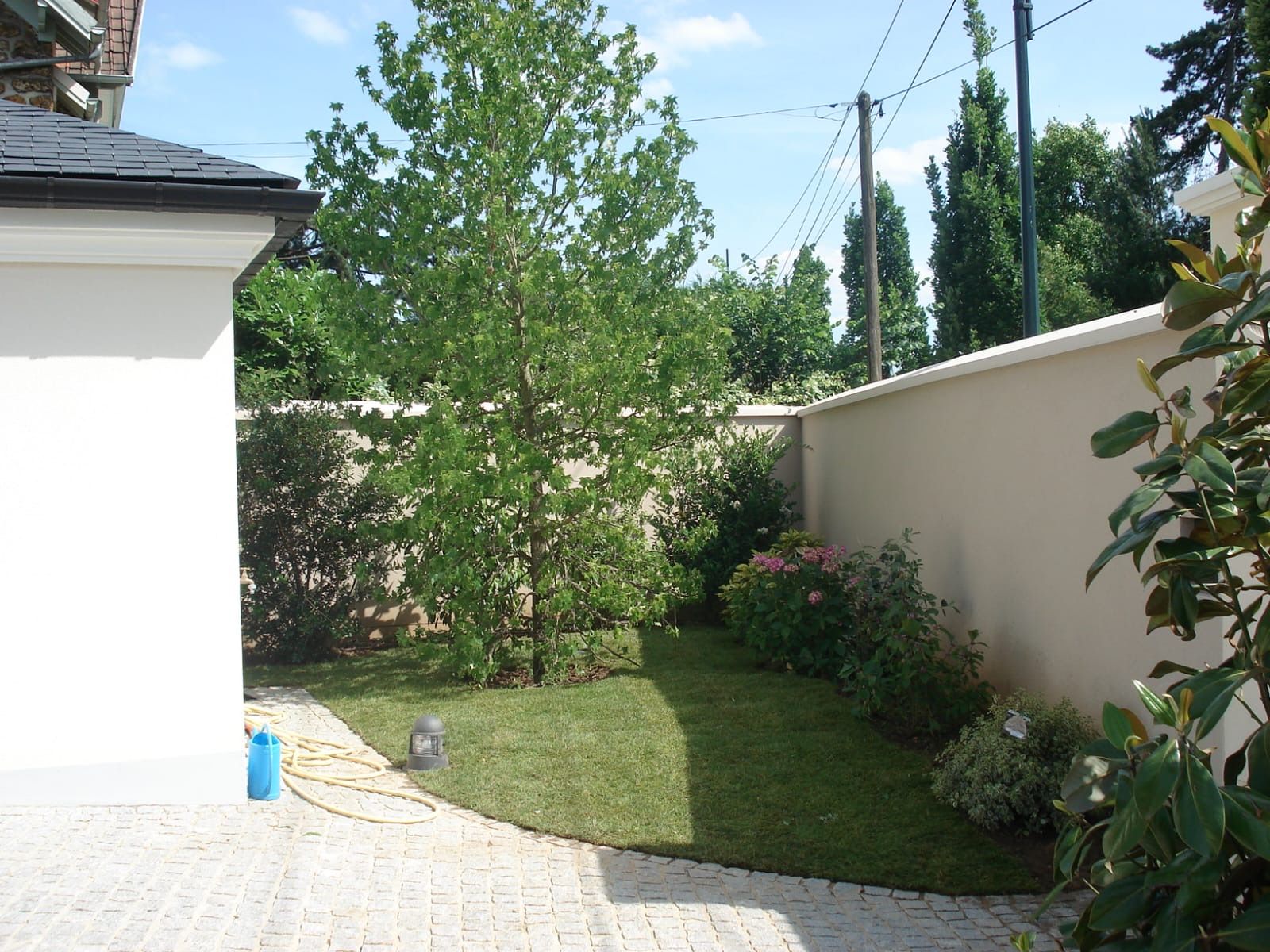 Photo de terrasse avec petit jardin et un arbre après travaux