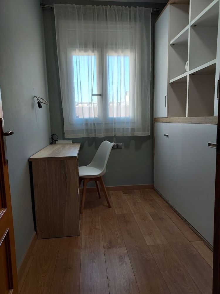 Un dormitorio con un sofá y una litera.