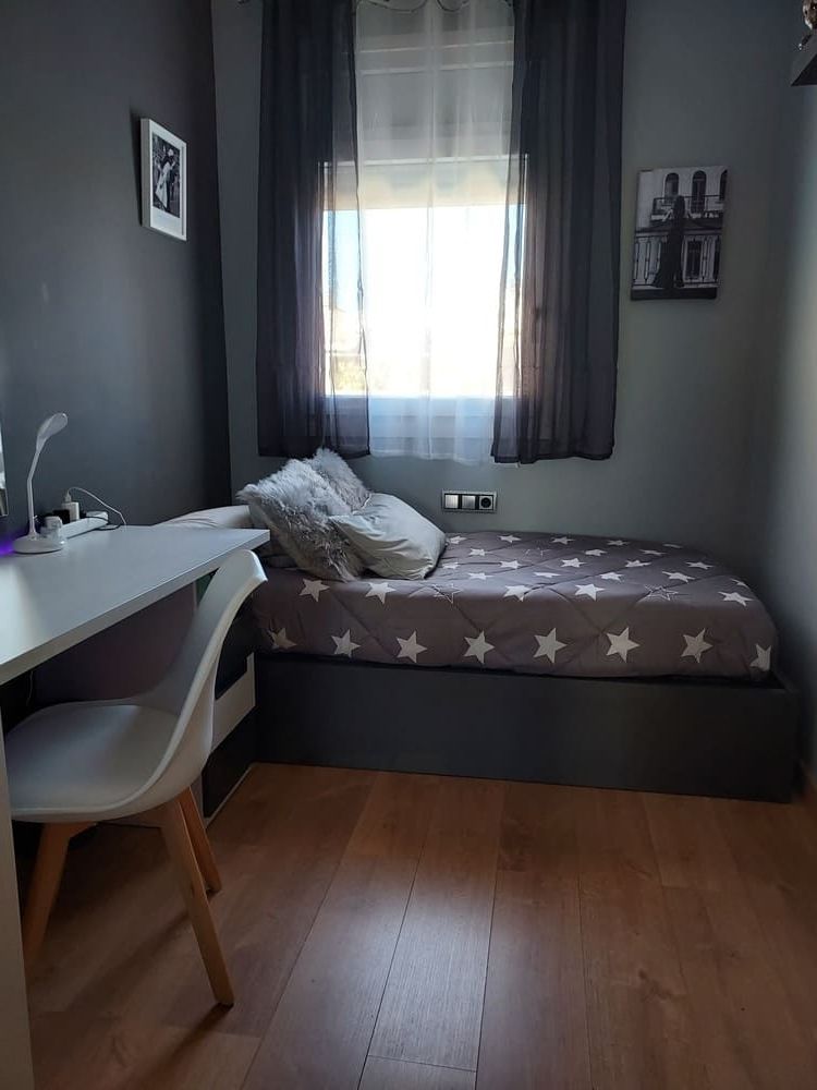 Un dormitorio con una cama con cajones y una cómoda.