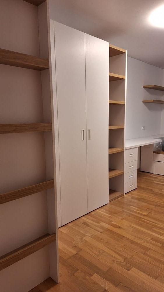 Un dormitorio con una cama y un escritorio con una computadora portátil encima.