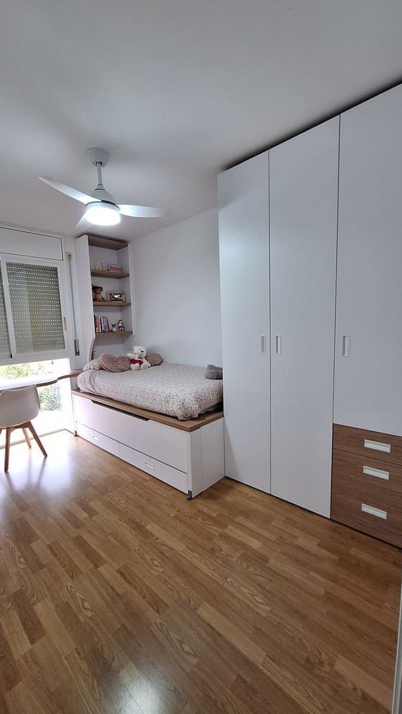 Un dormitorio con una cama y un escritorio con una computadora portátil encima.