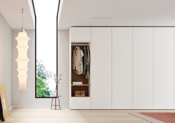 Una habitación con paredes blancas y una ventana grande.