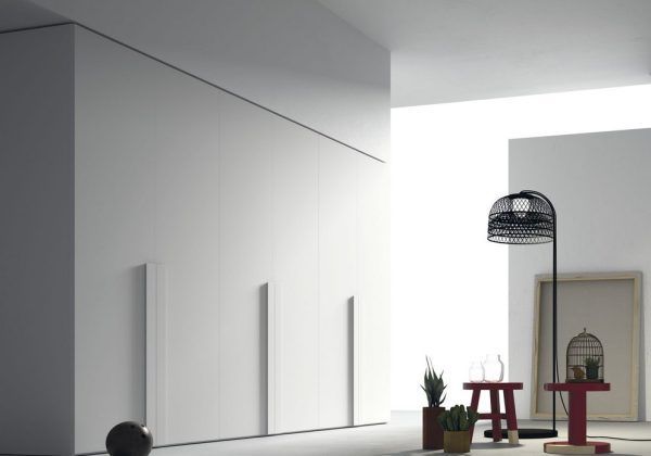 Una sala de estar con paredes blancas y una lámpara.