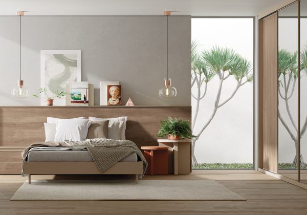 Un dormitorio con una cama, mesitas de noche y una gran ventana.