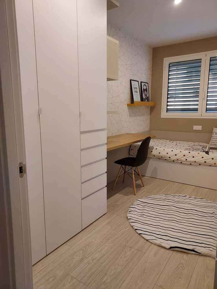 Un dormitorio con una cama con cajones y una cómoda.