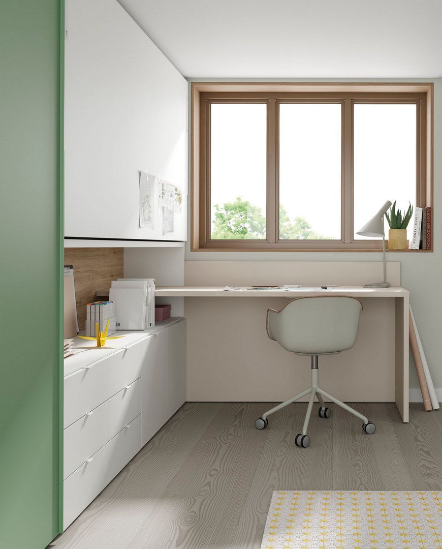 Una habitación con un escritorio y una silla frente a una ventana.