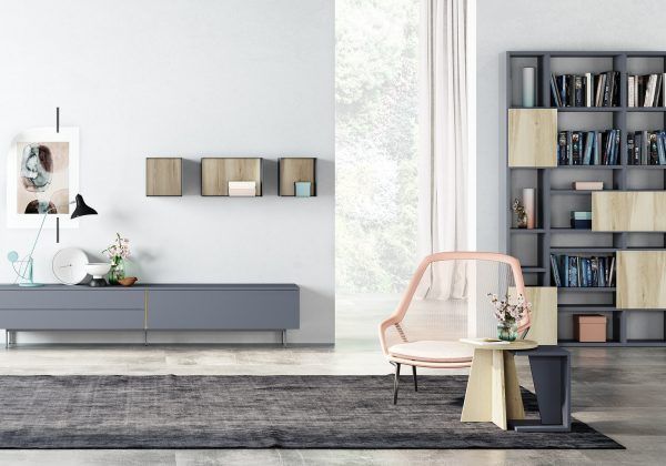 Una sala de estar con una estantería y una silla.