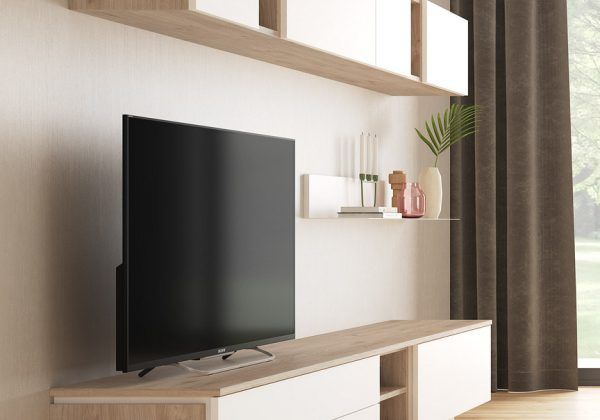 Un televisor de pantalla plana está sobre un centro de entretenimiento de madera en una sala de estar.