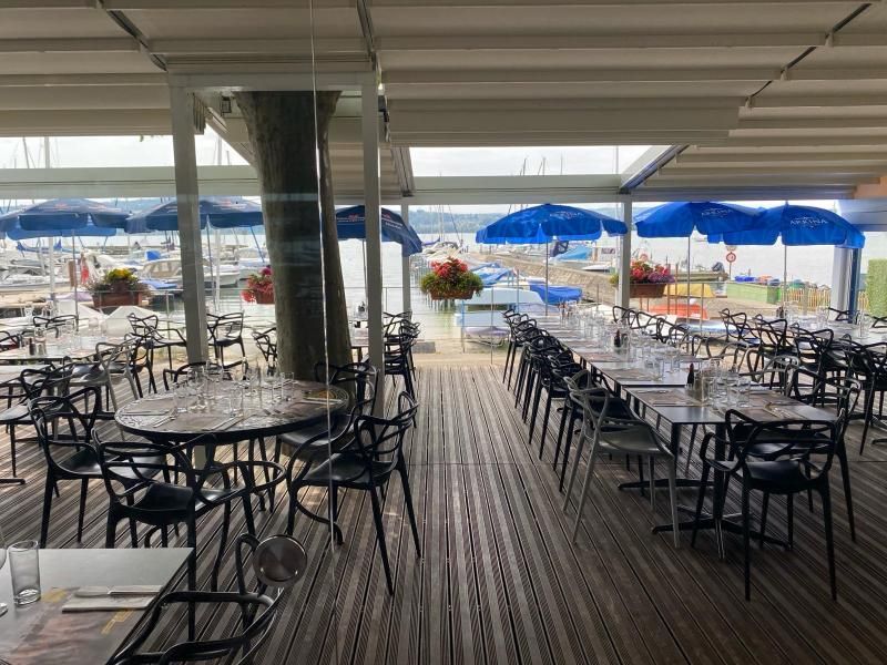 Le restaurant avec tables et chaises et parasols bleus.