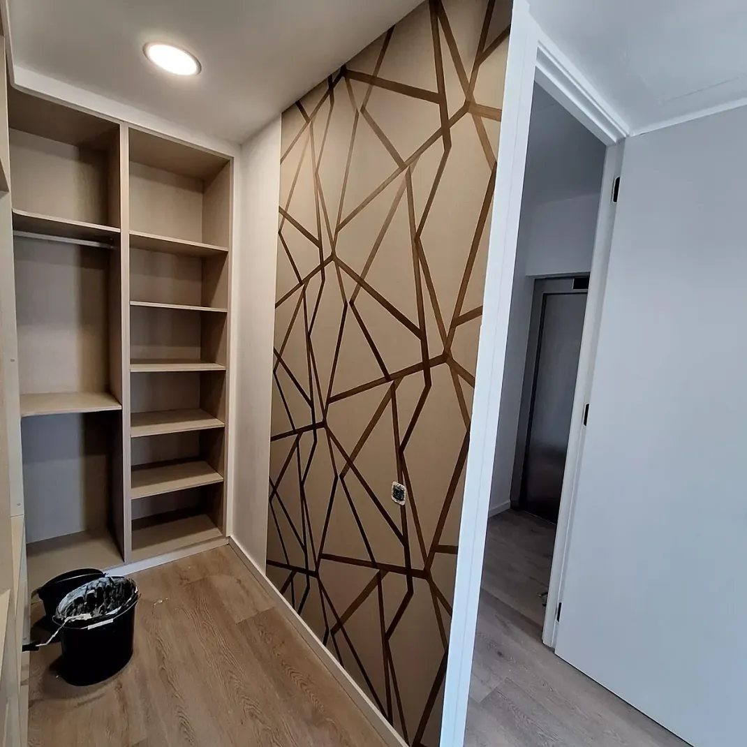 Un vestidor con un patrón geométrico en la pared.