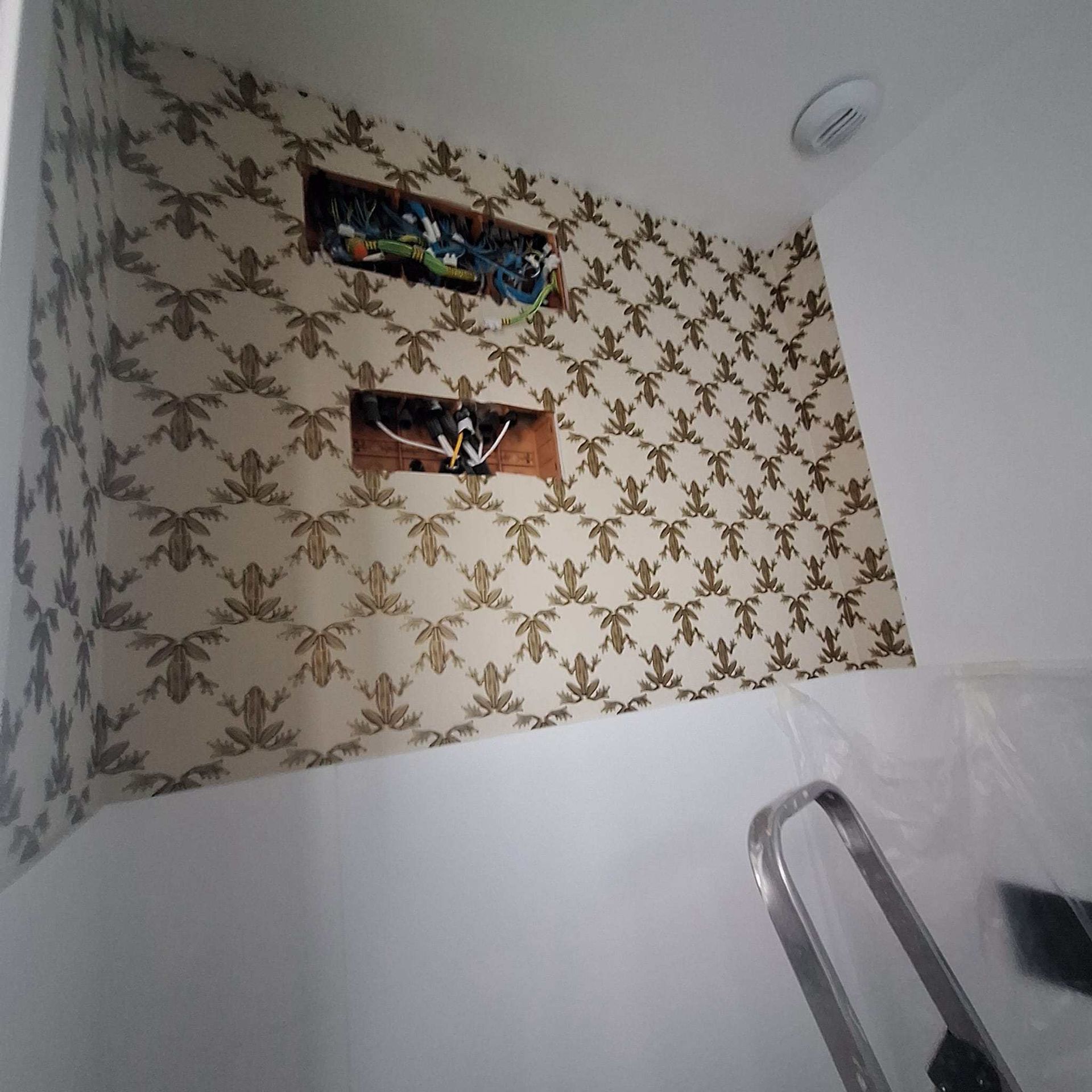 Un rincón de una habitación con un papel pintado estampado