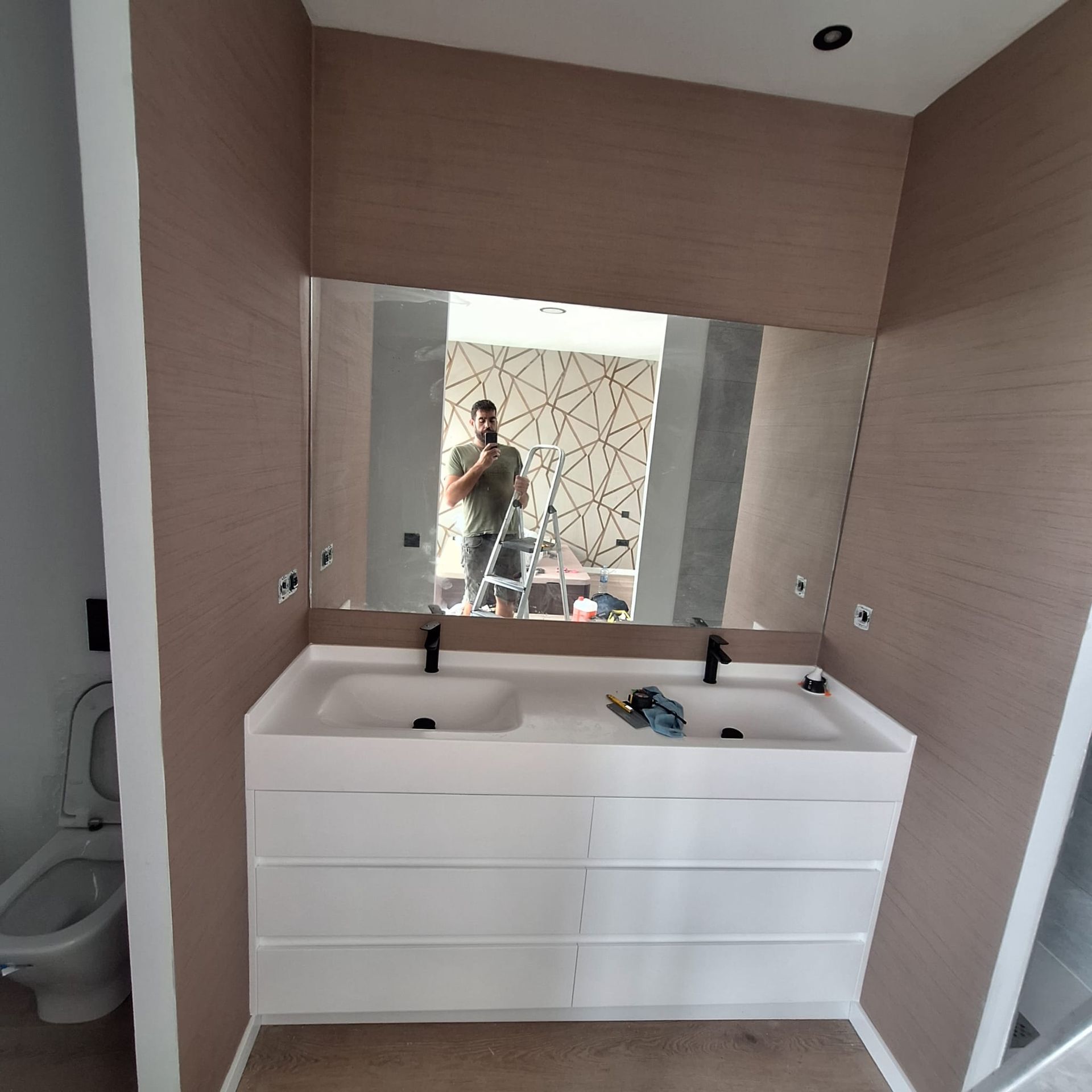 Un baño con dos lavabos y un espejo grande.