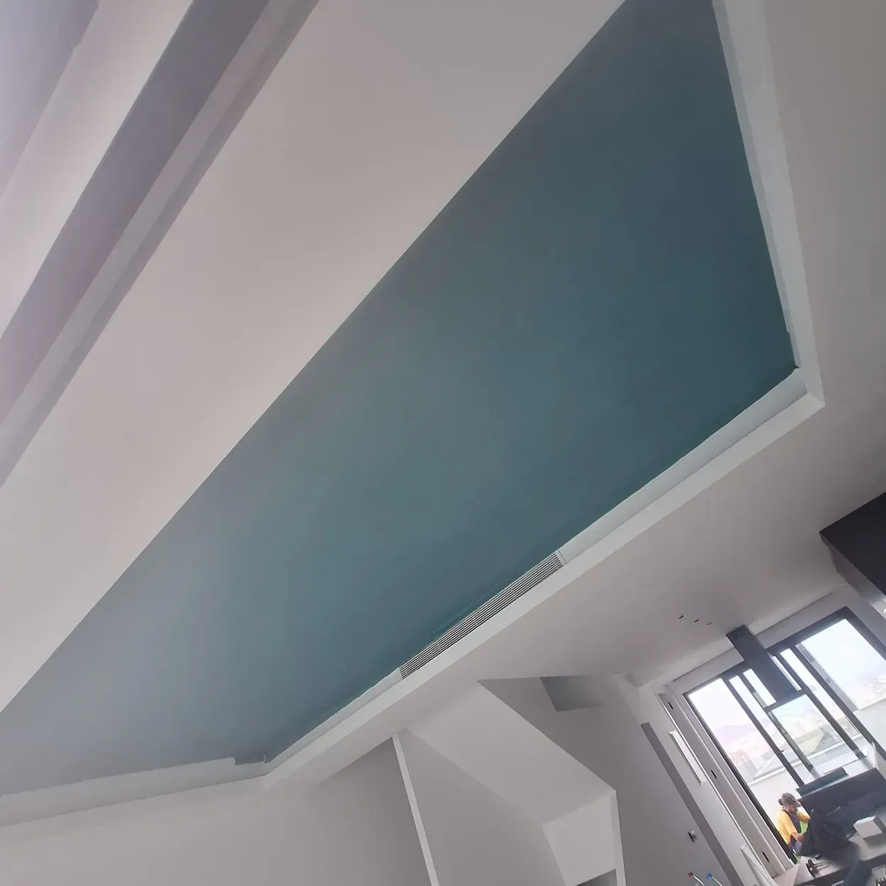 Una habitación con techo azul y paredes blancas