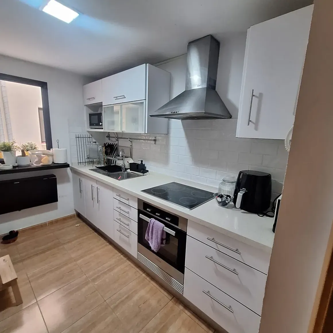 Una cocina con gabinetes blancos y un horno de estufa.
