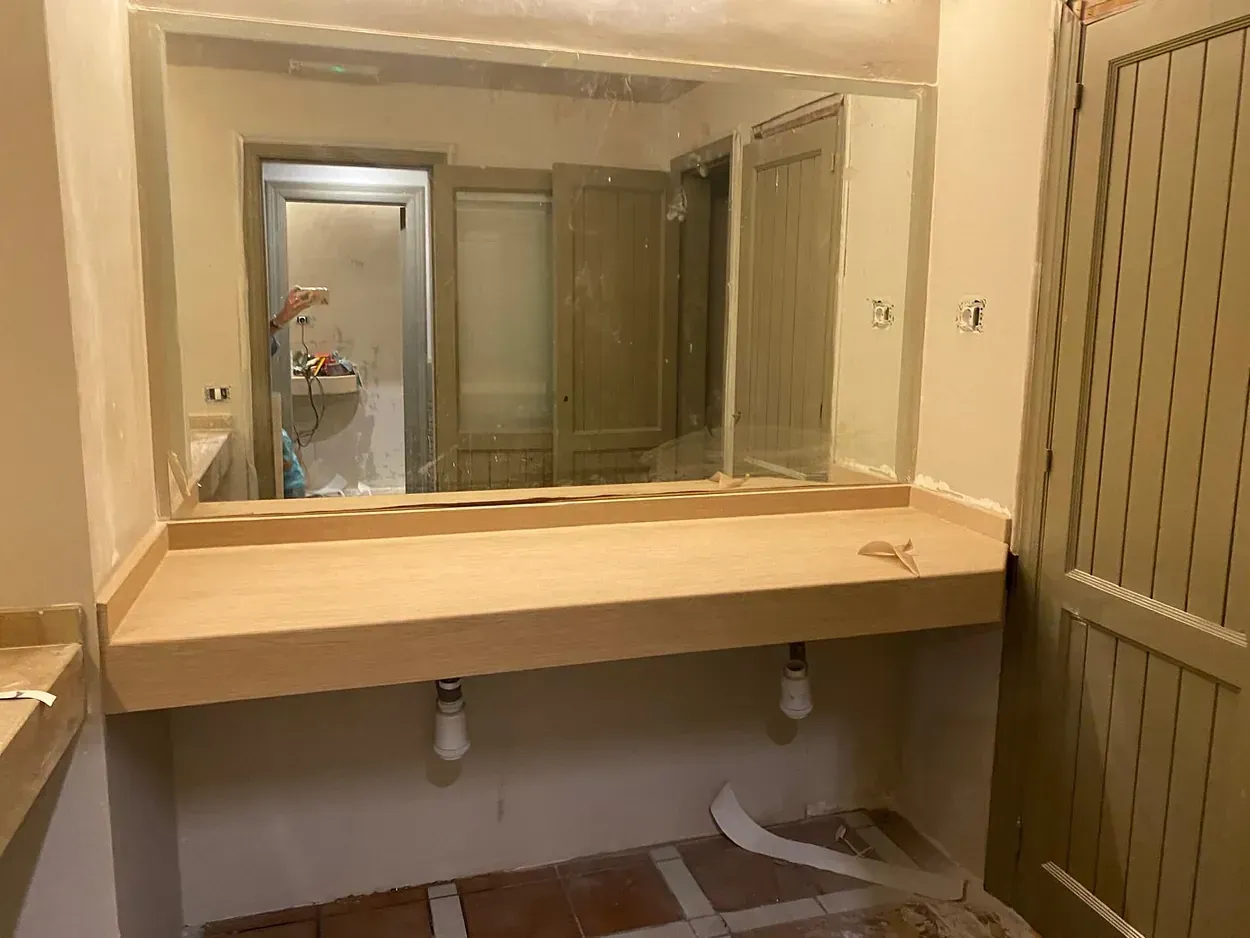 Un baño con tocador y un espejo grande.