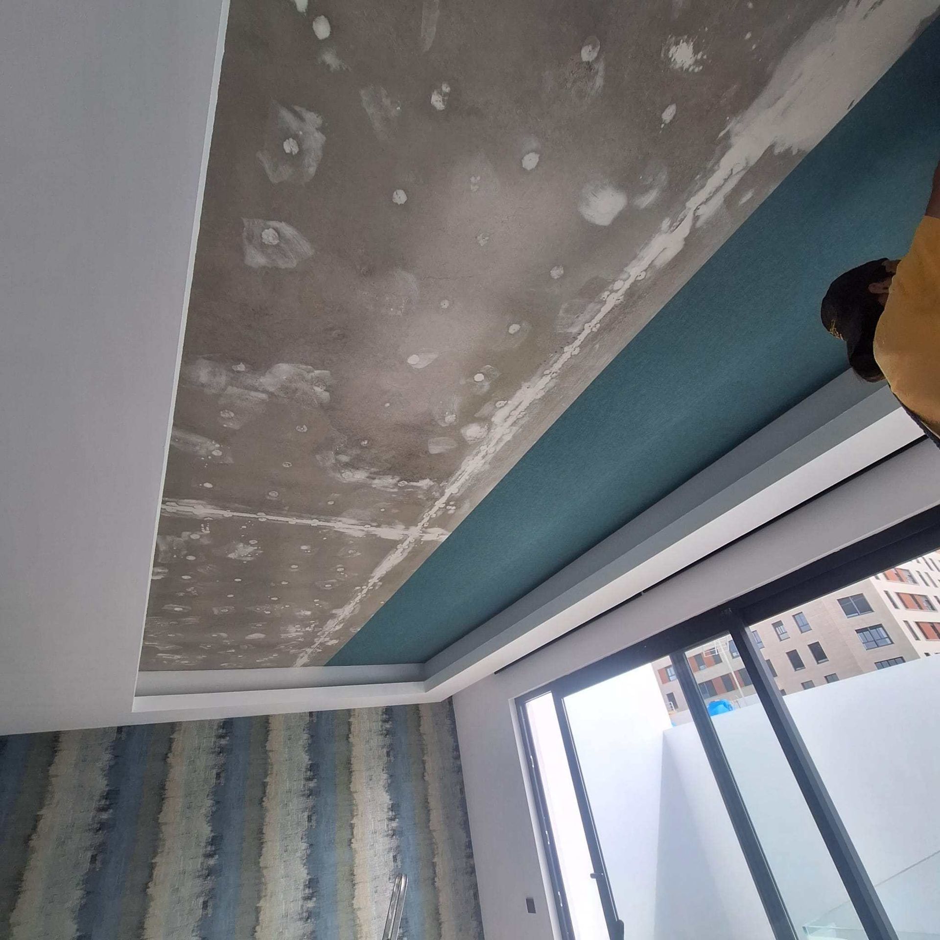 Una persona está mirando hacia el techo de una habitación.