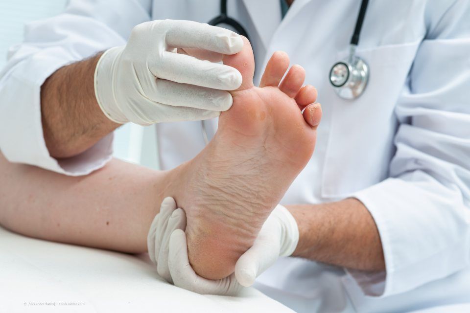 Podologe untersucht einen Fuß