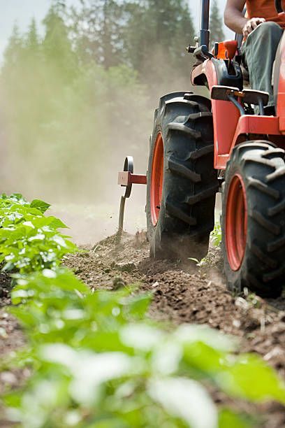 Une vue aérienne d'un tracteur labourant un champ.