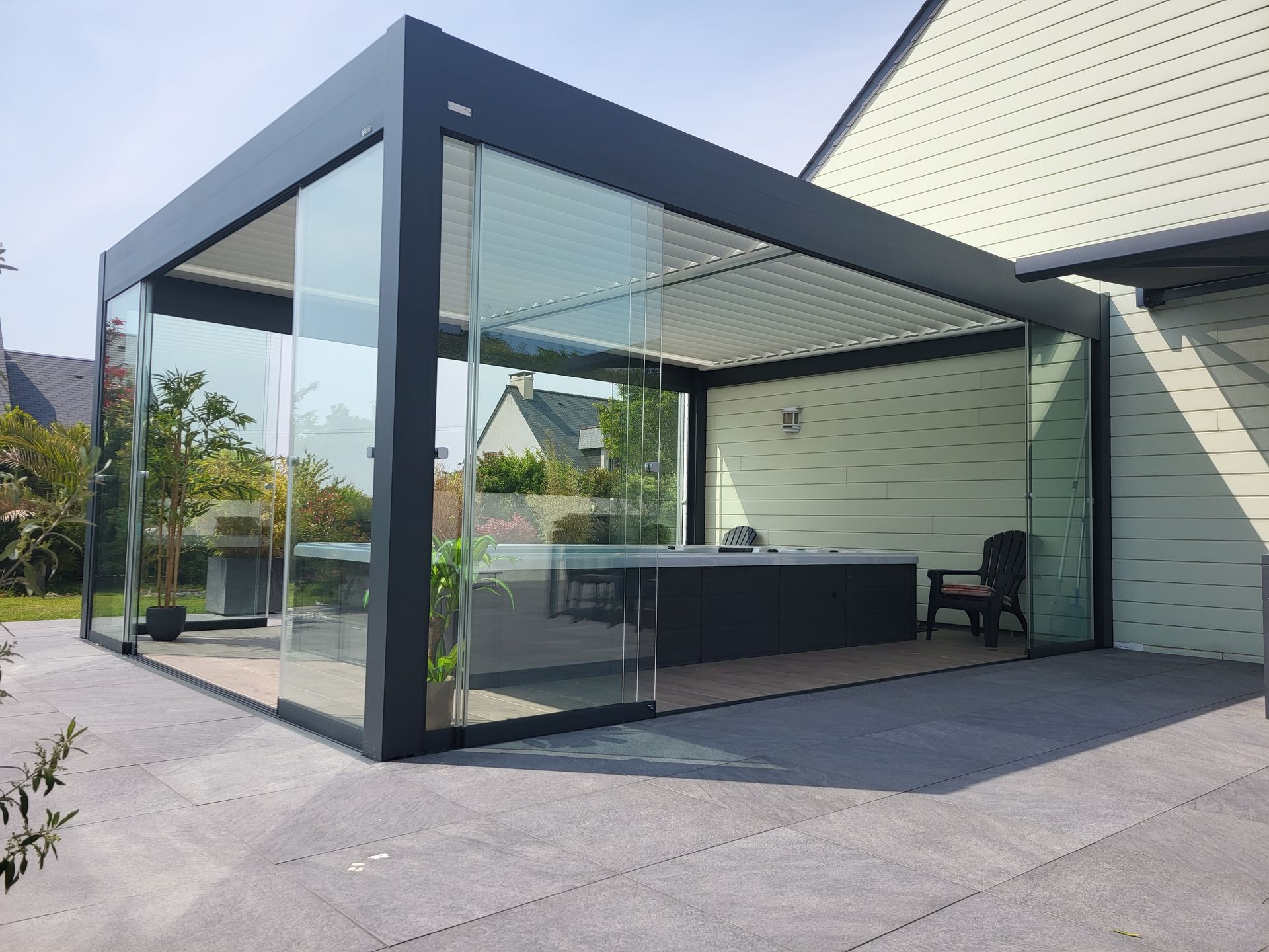 Véranda en verre adjacente à une maison