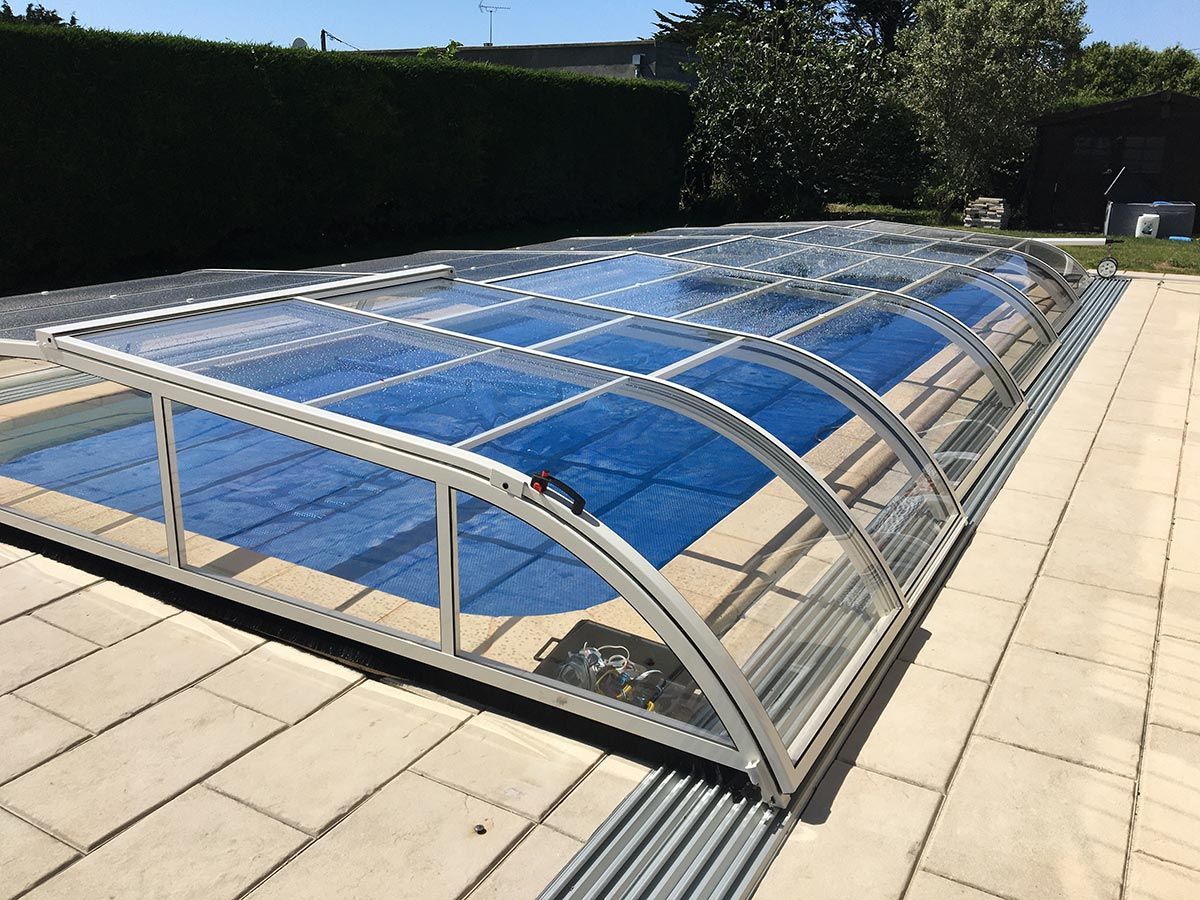 Abri de piscine bas en aluminium blanc vu de coté