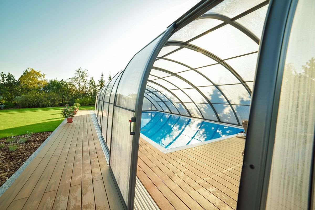 Abri de piscine haut vu de coté avec une terrasse en bois