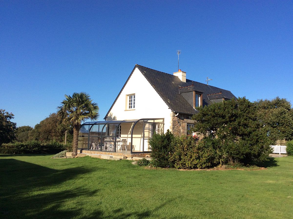 Abris devant une maison sur une terrasse avec un palmier