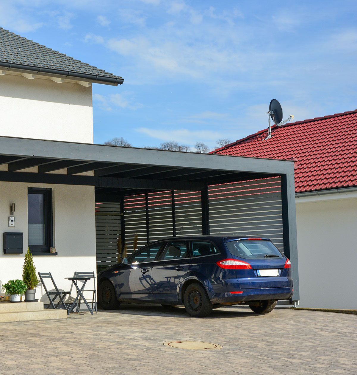 Carport avec une voiture bleu garée dessous