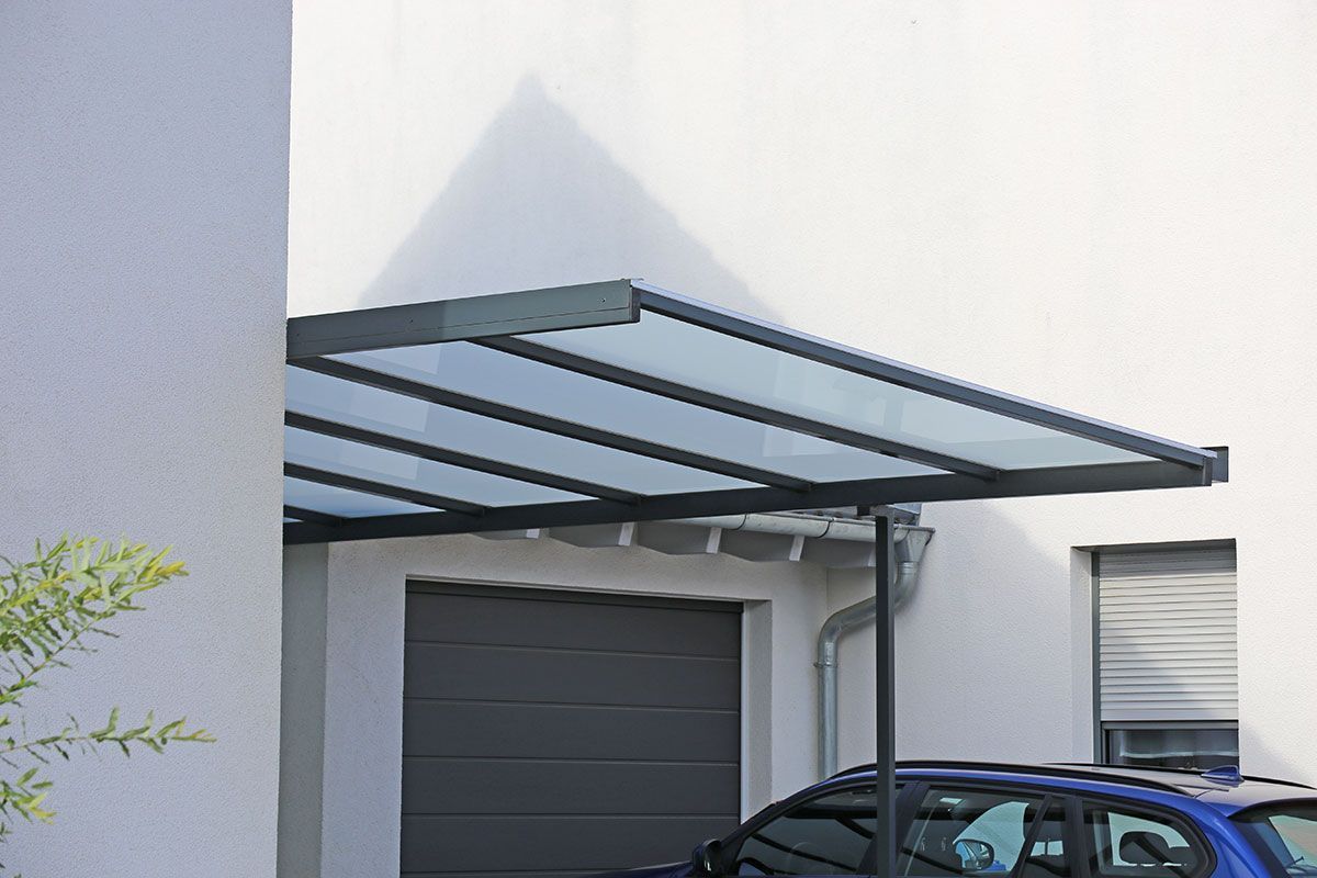 Carport avec une voiture bleu garée dessous