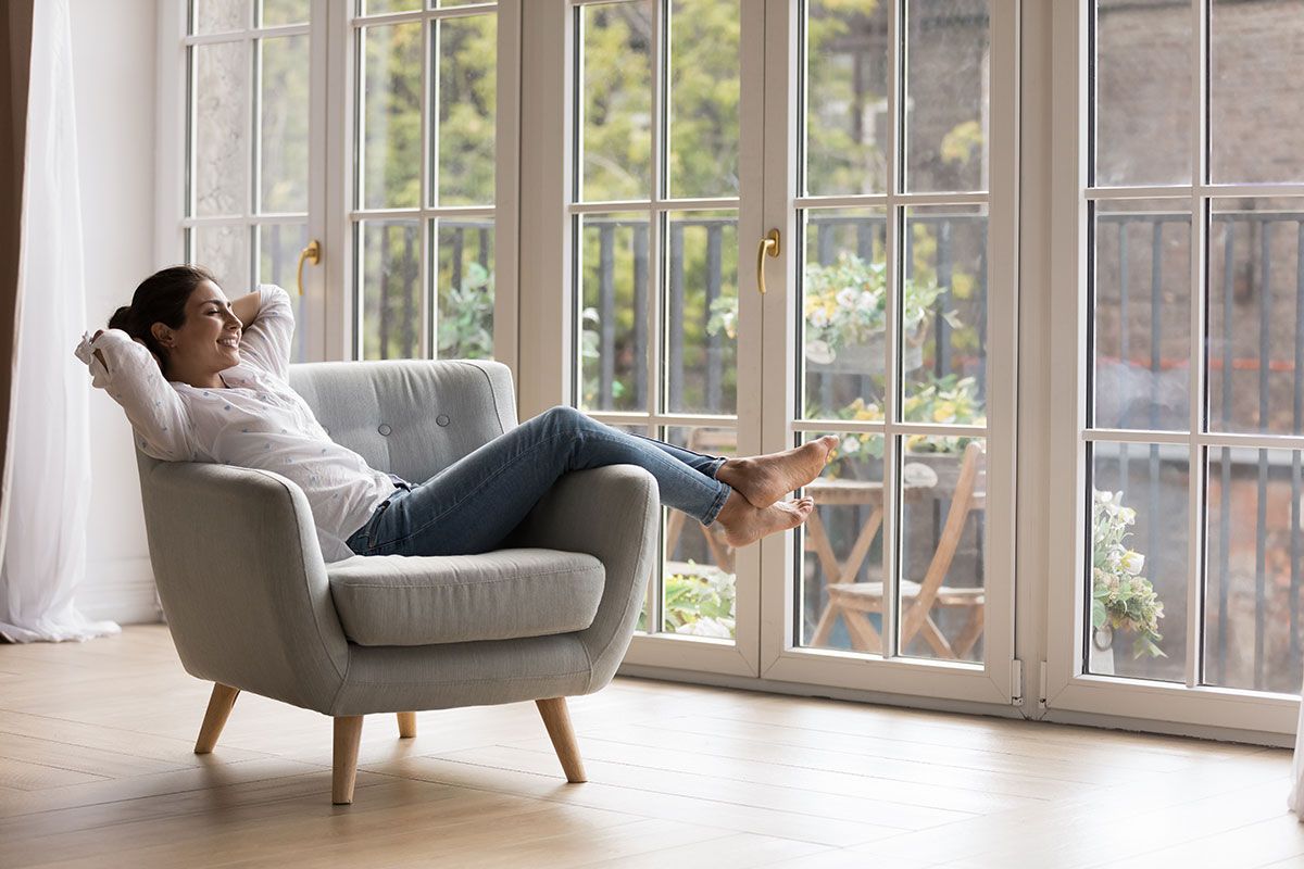 Femme assise sur un fauteuil devant une fenêtre