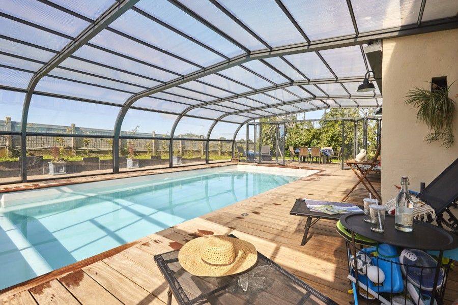 Zoom sur une piscine avec abri et un chapeau sur une chaise  longue