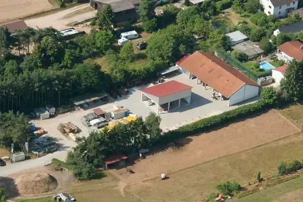 Luftaufnahme eines Bauunternehmens mit Lagerfläche und Betriebsgebäude Luftaufnahme eines Bauunternehmens mit Lagerfläche und Betriebsgebäude