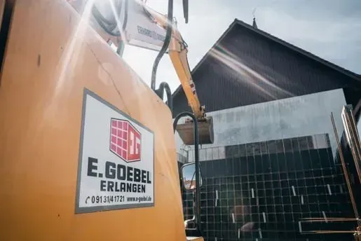 Bagger bei Neubauarbeiten auf moderner Hochbaubaustelle Bagger bei Neubauarbeiten auf moderner Hochbaubaustelle