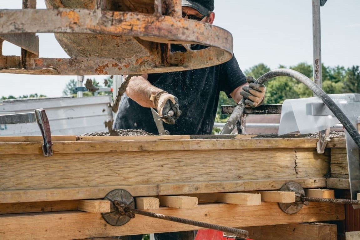 Betonarbeiten am Holzrahmenbau auf moderner Baustelle