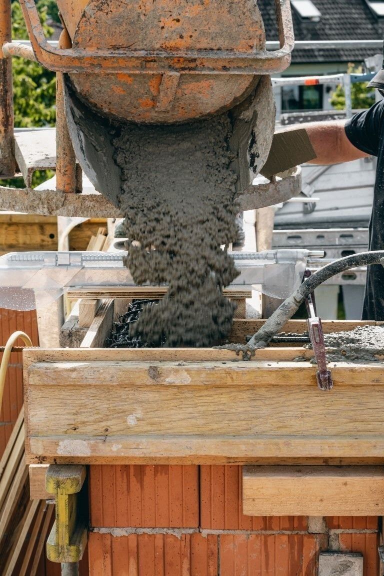 Frischer Beton aus Betonmischer bei Rohbauarbeiten am Wohnhaus