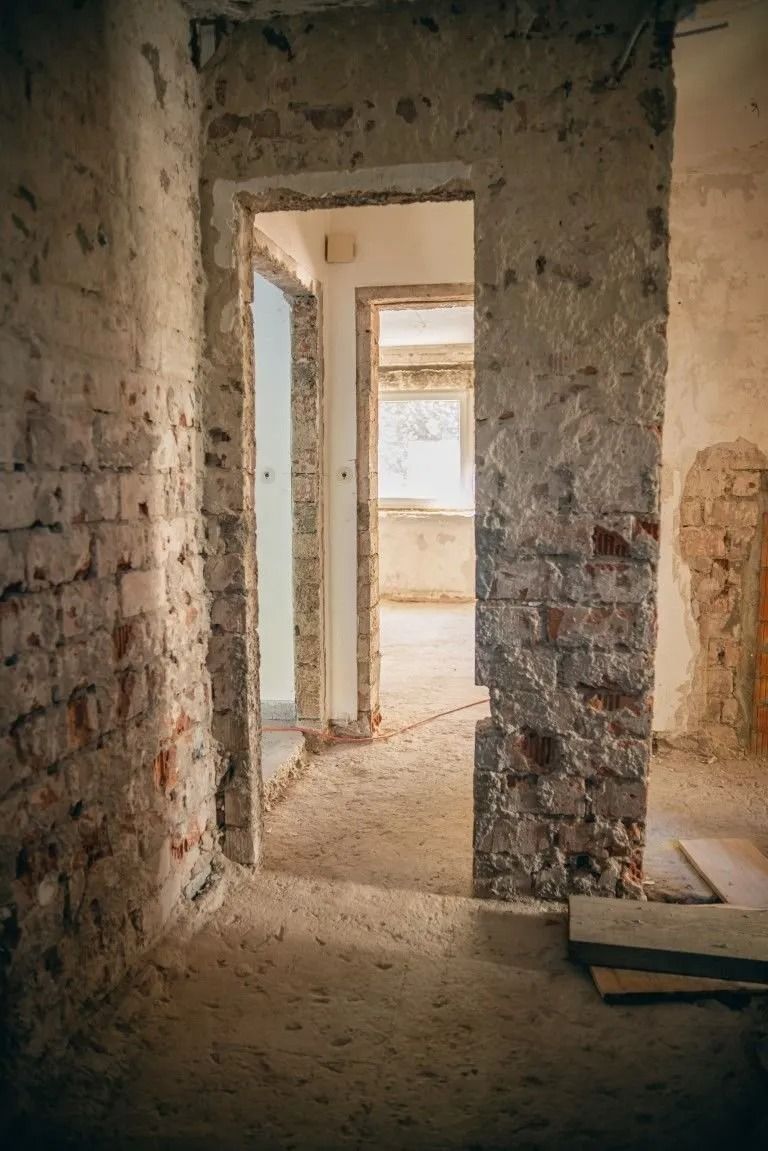 Rohbauflur bei Sanierungsarbeiten in einem Altbau mit freigelegten Wänden