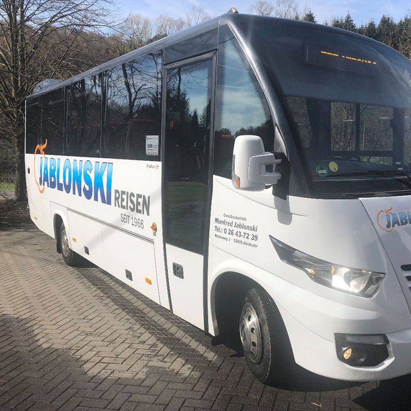 Ein weißer Bus mit der Aufschrift „Tablowski Reisen“ an der Seite