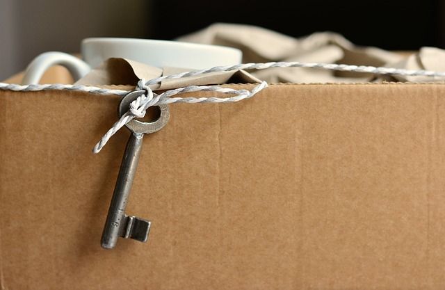 Une vieille clé en métal suspendue à une ficelle sur le bord d'une boîte en carton