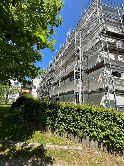 Gebäude mit aufwendigem Baugerüst unter blauem Himmel.