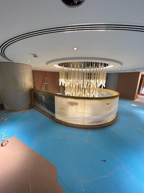 Luxuriöse Decke mit Kronleuchter und indirekter Beleuchtung.