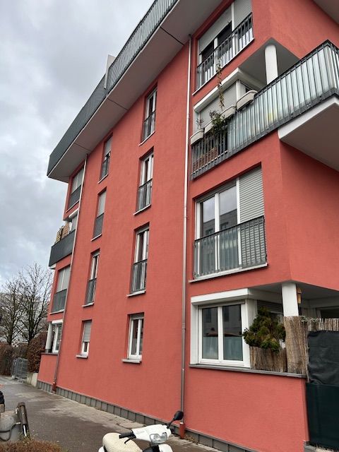 Rote Hausfassade mit Balkonen.