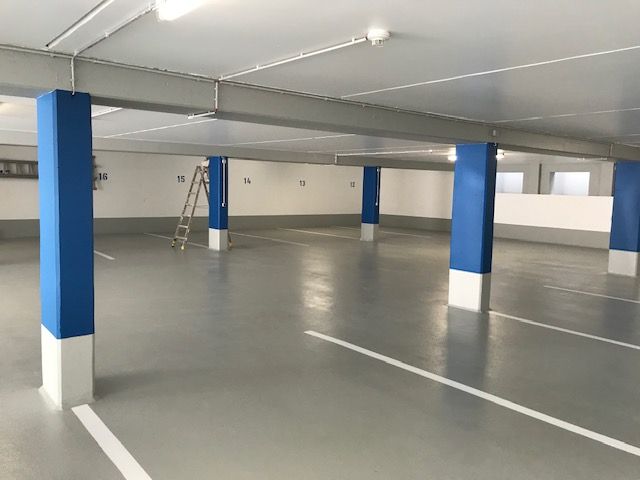 Große Parkhalle mit blauen Säulen und neuem Boden.