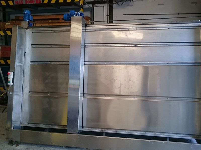 Máquina industrial de gran tamaño, fabricada en acero inoxidable, con una columna de soporte central, motores azules en la parte superior y una caja de control en el lateral.