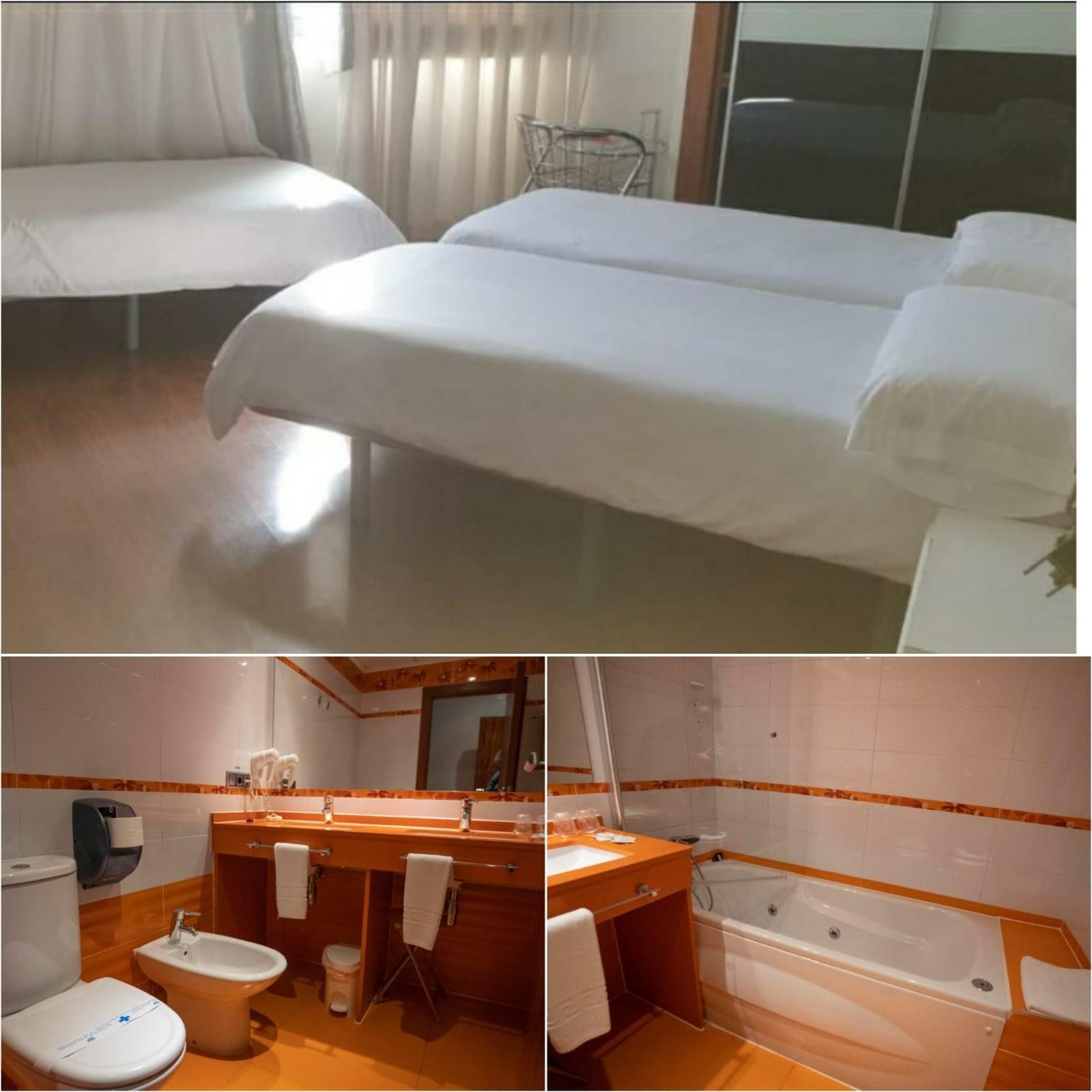Habitación de hotel con dos camas y una cama individual, además de baño con inodoro, bidet, lavabo y bañera.