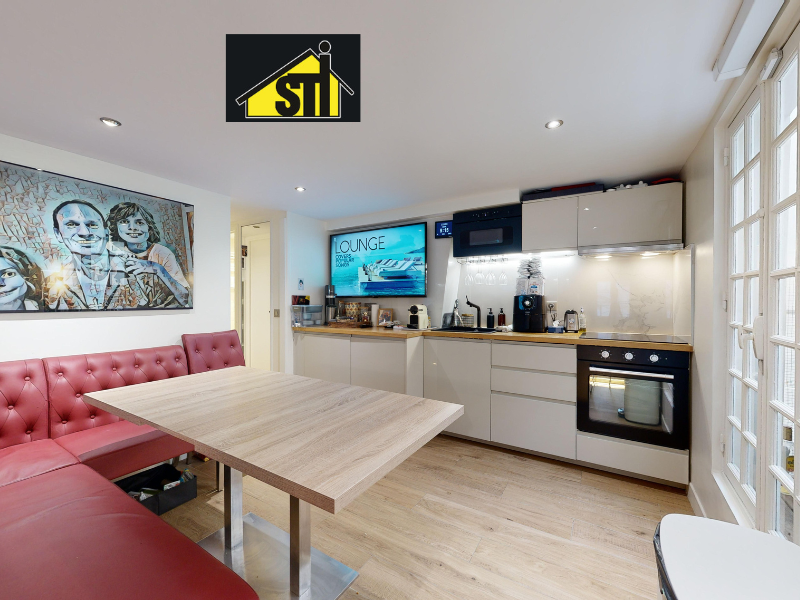 Vue de la cuisine de l'appartement avec grande fenêtre.