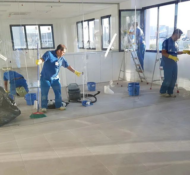 Un hombre está limpiando una habitación con una aspiradora.