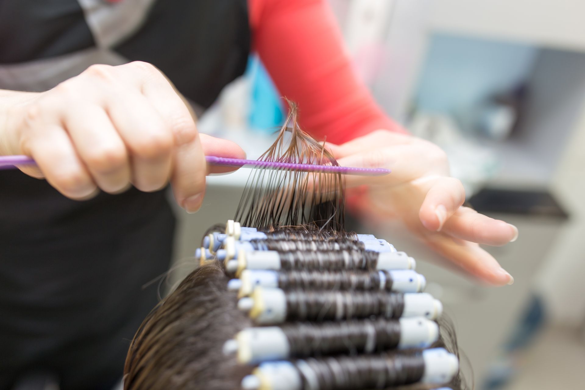 Mise en pli avec de petits rouleaux sur les cheveux d'une cliente