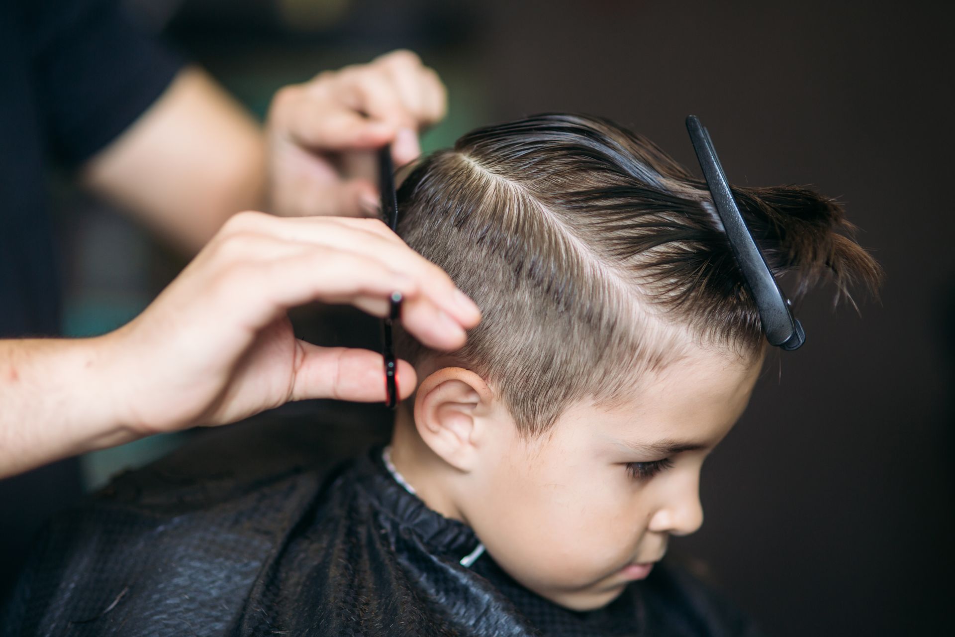 Coiffeur coupant les cheveux d'un petit garçon