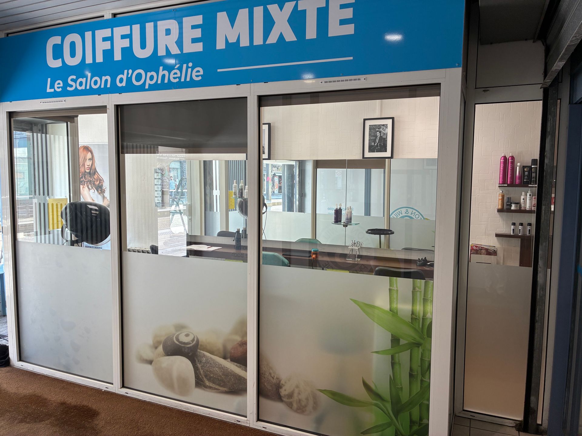 Façade du salon Coiffure Mixte – Le Salon d’Ophélie, un salon de coiffure bleu et blanc aux vitres givrées